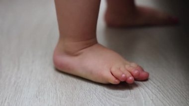 Bebek bacakları vücut kompozisyon ölçeğinde yalınayak ağırlığı ev içi lamine ahşap zemin zemin zemin zemin yatağı ve bebek beşiği. Beyaz ölçekli şişman dijital sayılarda şirin bebek bacakları.