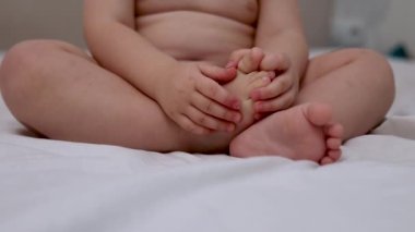 Ağlayan bebek yatakta uzanıyor, elleriyle gözlerini ovuyor. Kızgın, uykulu, üzgün, tatminsiz çocuk beşiğinde kalmayı reddediyor. Sevimli çocuk popuyla oynuyor.