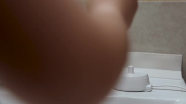 Unge Pojke Tvätta Tänder Med Elektrisk Badrummet Ser Spegel Och — Stockvideo