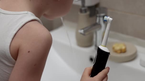 男孩儿在浴室里用电洗牙 看着镜子 可爱的学龄前儿童用天然的生物有机肥皂日历提取物洗手 — 图库视频影像