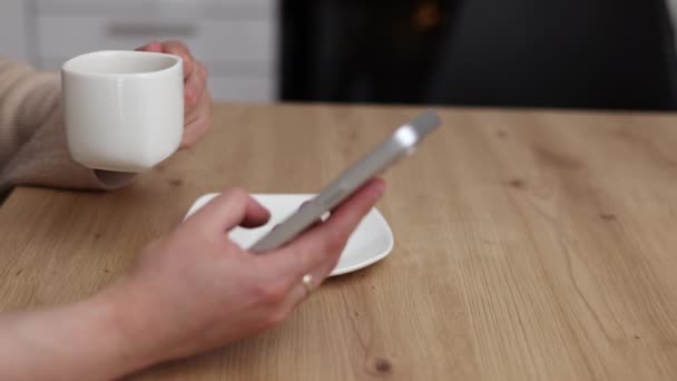 Millennial Kvinna Sitter Köket Dricka Kaffe Med Hjälp Smartphone Leende — Stockvideo