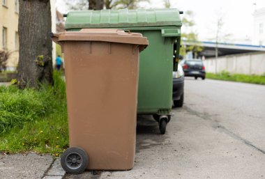 Şehir çevresindeki birçok çöp kutusu. Çöp sepeti kirli sokak kaldırımlarıyla dolu. Tekerlekli çöp tenekesi..