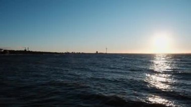 Rüzgarlı bir pazar öğleden sonra, deniz kenarında. Parlayan güneş ve kıyıya vuran dalgalar.