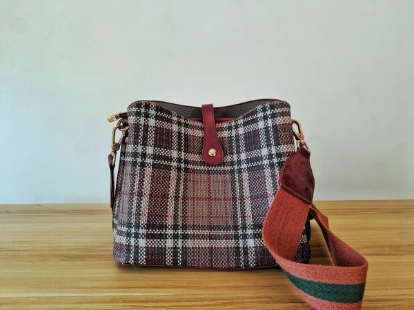 A women fabric sling bag on brown table taken from backside