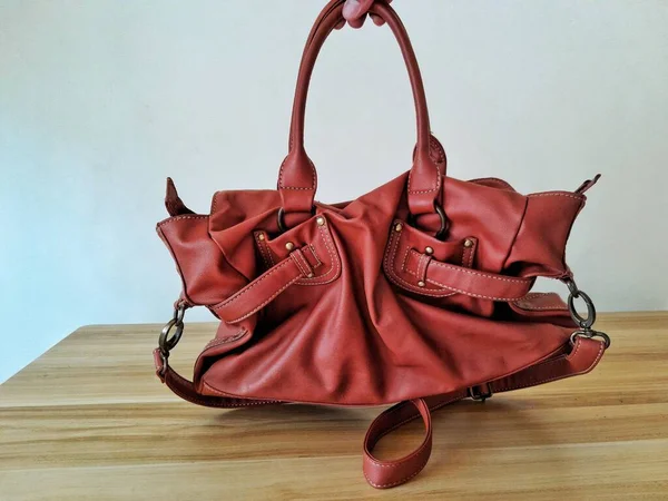 A women brown leather bag capture hanging by hand