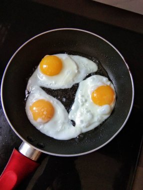 Tavada pişmiş üç güneşli yumurta.
