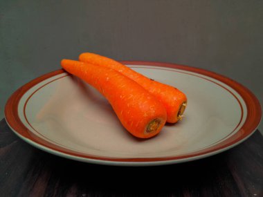 Kahverengi seramik tabakta turuncu havuçlar.