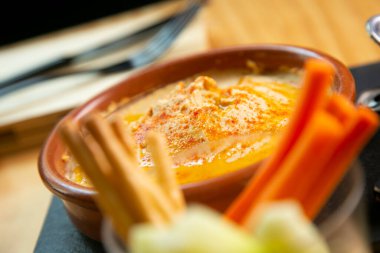 Hummus is a cream of chickpeas cooked with lemon juice, which includes tahini paste and olive oil, which, depending on the local variant, can also include other ingredients such as garlic or paprika.