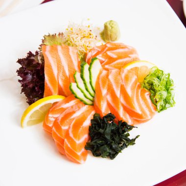 Salmon sashimi. Sashimi is a Japanese dish that consists mainly of raw seafood or fish, finely sliced, although not as finely as a carpaccio.