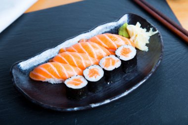 Set of sushi with variety of makis, nigiris and sashimi with fine fish like salmon and tuna.