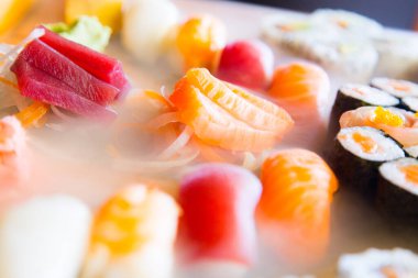 Set of sushi with variety of makis, nigiris and sashimi with fine fish like salmon and tuna.