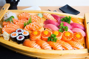Set of sushi with variety of makis, nigiris and sashimi with fine fish like salmon and tuna.