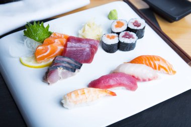 Set of sushi with variety of makis, nigiris and sashimi with fine fish like salmon and tuna.