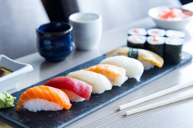 Set of sushi with variety of makis, nigiris and sashimi with fine fish like salmon and tuna.