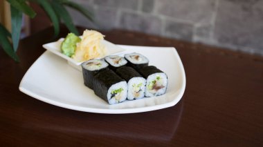 Maki sushi with rice and seaweed stuffed with vegetables and vegetarian ingredients.