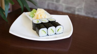 Maki sushi with rice and seaweed stuffed with vegetables and vegetarian ingredients.