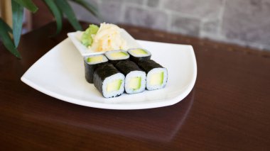 Maki sushi with rice and seaweed stuffed with vegetables and vegetarian ingredients.
