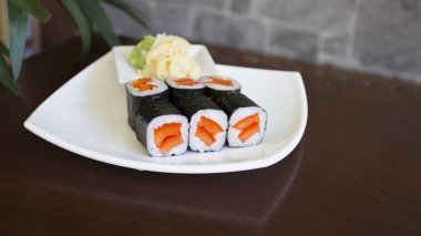Maki sushi with rice and seaweed stuffed with vegetables and vegetarian ingredients.
