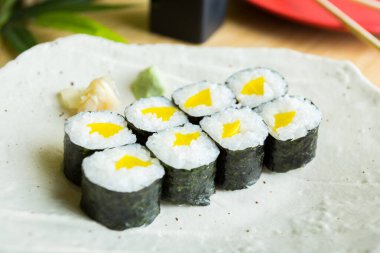 Maki sushi with rice and seaweed stuffed with vegetables and vegetarian ingredients.