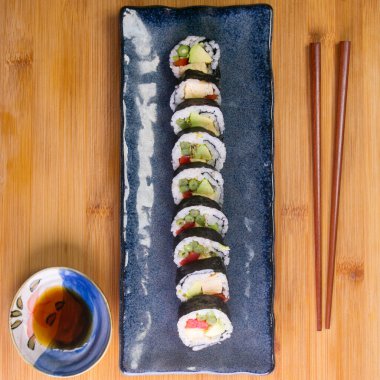 Maki sushi with rice and seaweed stuffed with vegetables and vegetarian ingredients.