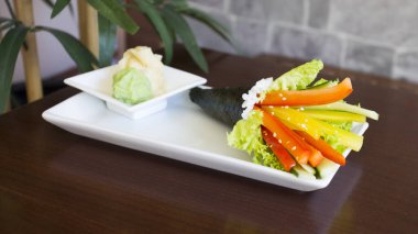 Vegan temaki with vegetables. Temaki is a type of sushi that consists of a seaweed cone stuffed with rice typical of Japanese cuisine.