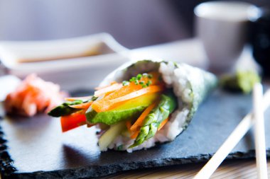 Vegan temaki with vegetables. Temaki is a type of sushi that consists of a seaweed cone stuffed with rice typical of Japanese cuisine.