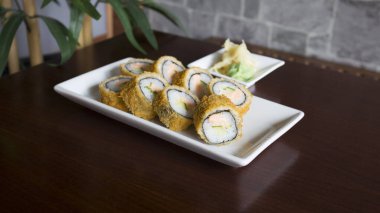 Hot roll fried  Sushi Roll with Salmon and Vegetables. Modern sushi recipe in Japan.