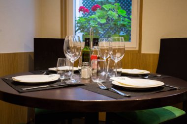 Elegant restaurant table with cutlery, crockery and glasses.