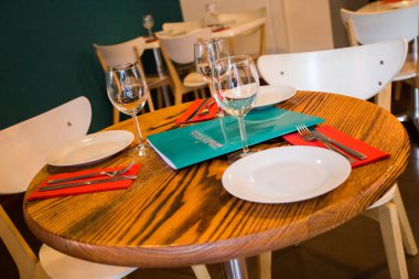 Elegant restaurant table with cutlery, crockery and glasses.