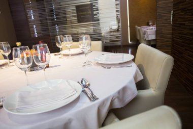 Elegant restaurant table with cutlery, crockery and glasses.