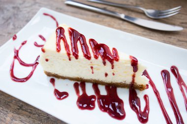 Cheesecake with red fruit sauce and fresh fruit such as raspberries, blueberries or strawberries.