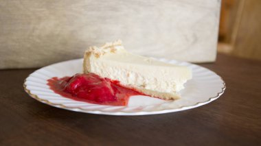 Cheesecake with red fruit sauce and fresh fruit such as raspberries, blueberries or strawberries.