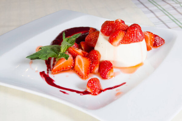 Cheesecake with red fruit sauce and fresh fruit such as raspberries, blueberries or strawberries.