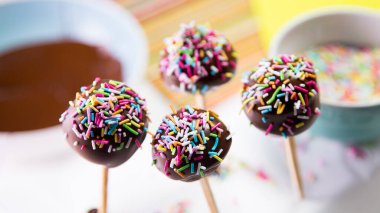 Cake pops with chocolate coating and colored sprinkles