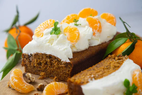 Carrot cake with white frosting and tangerine pieces