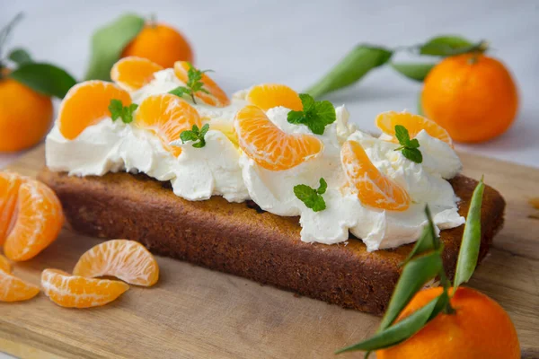 Carrot cake with white frosting and tangerine pieces