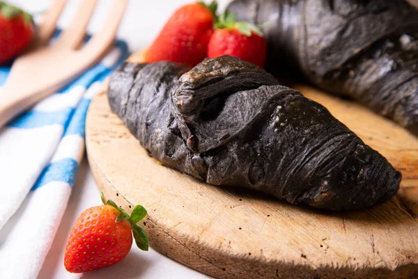 Croissant made with activated charcoal. Vegan breakfast.