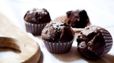 Chocolate muffins with chocolate chips inside.