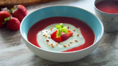 Bowl with Greek yogurt and strawberry sauce.