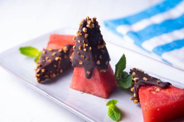 Chunks of fresh watermelon dipped in chocolate and covered with caramelized almonds.