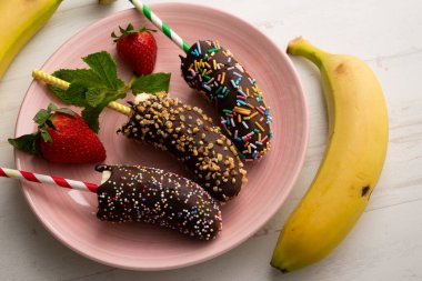 Bananas dipped in dark chocolate and covered with decorative caramel.