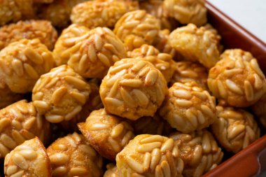 Penellets. Small sweets of various shapes, made from almond and potato dough, and covered with almonds or pine nuts.