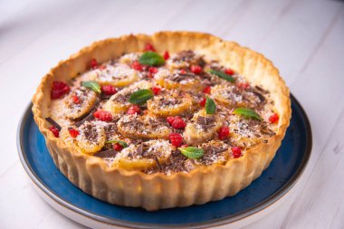 Banana yoghurt sponge cake with pieces of fresh fruit and chocolate on top