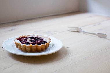 Raspberry tarts on a plate with raspberries
