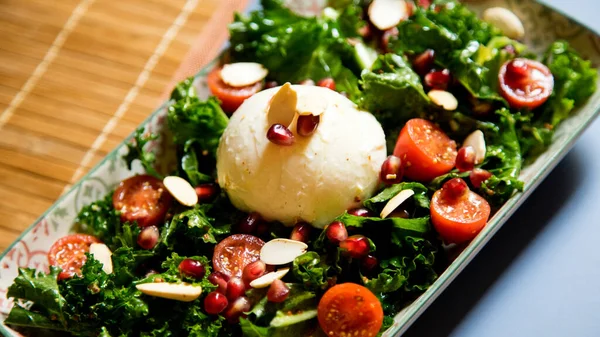 Delicious and healthy kale salad, mozzarella cheese and cherry tomatoes.