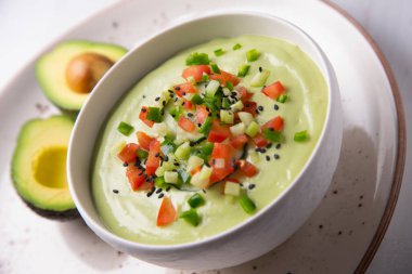 Avokado Gazpacho, zeytinyağı, sirke, su, çiğ sebze, domates, salatalık, biber ve sarımsak gibi çeşitli malzemelerle birlikte soğuk bir çorbadır..