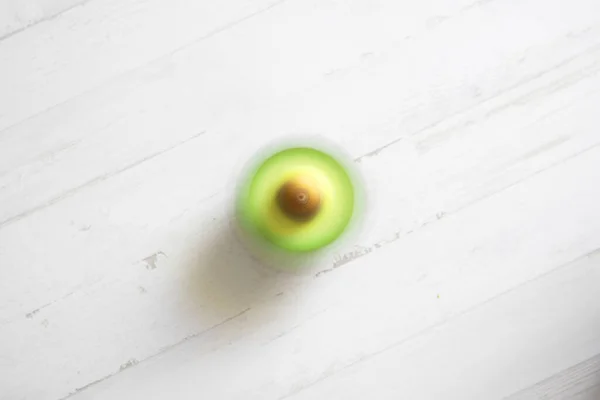Een Halve Avocado Zit Een Witte Tafel — Stockfoto
