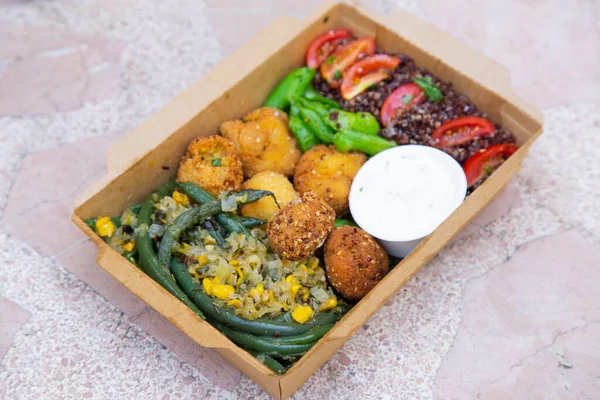 stock image Food box with vegetables and vegan croquettes. Delicious healthy takeaway menu.