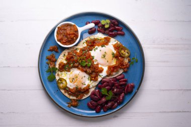 Huevos rancheros geleneksel bir Meksika kahvaltısıdır, temel olarak: domatesli kızarmış yumurta ve mısır tortillası.,