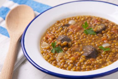 Patates, sucuk ve puding ile mercimek tabağı. Geleneksel İspanyol mercimek güveci..